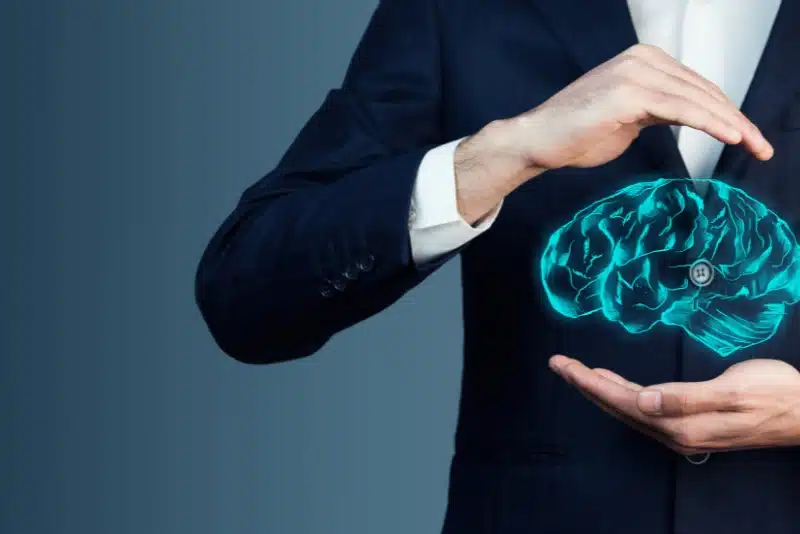 Businessman in suit protecting digital brain hologram—symbolizing intellectual property, creative rights, and online protection of original ideas from AI scraping and content theft.