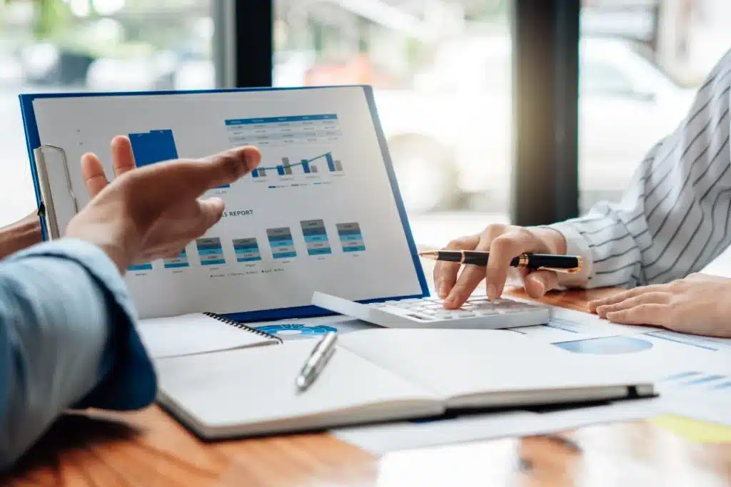 Business professionals reviewing data reports and analytics charts, discussing performance metrics and financial insights, representing structured data analysis and decision-making for scalable systems and digital infrastructure.